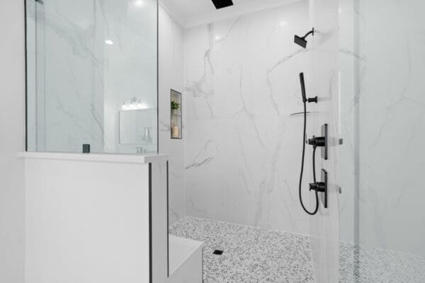 Modern bathroom with a glass shower and black fixtures.