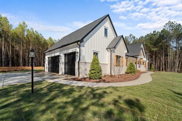 Modern suburban house with a three-car garage and landscaped yard.