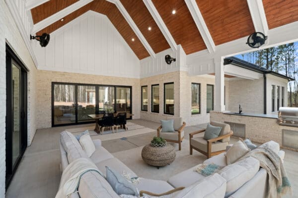 Spacious outdoor patio with cozy seating and wooden ceiling beams.