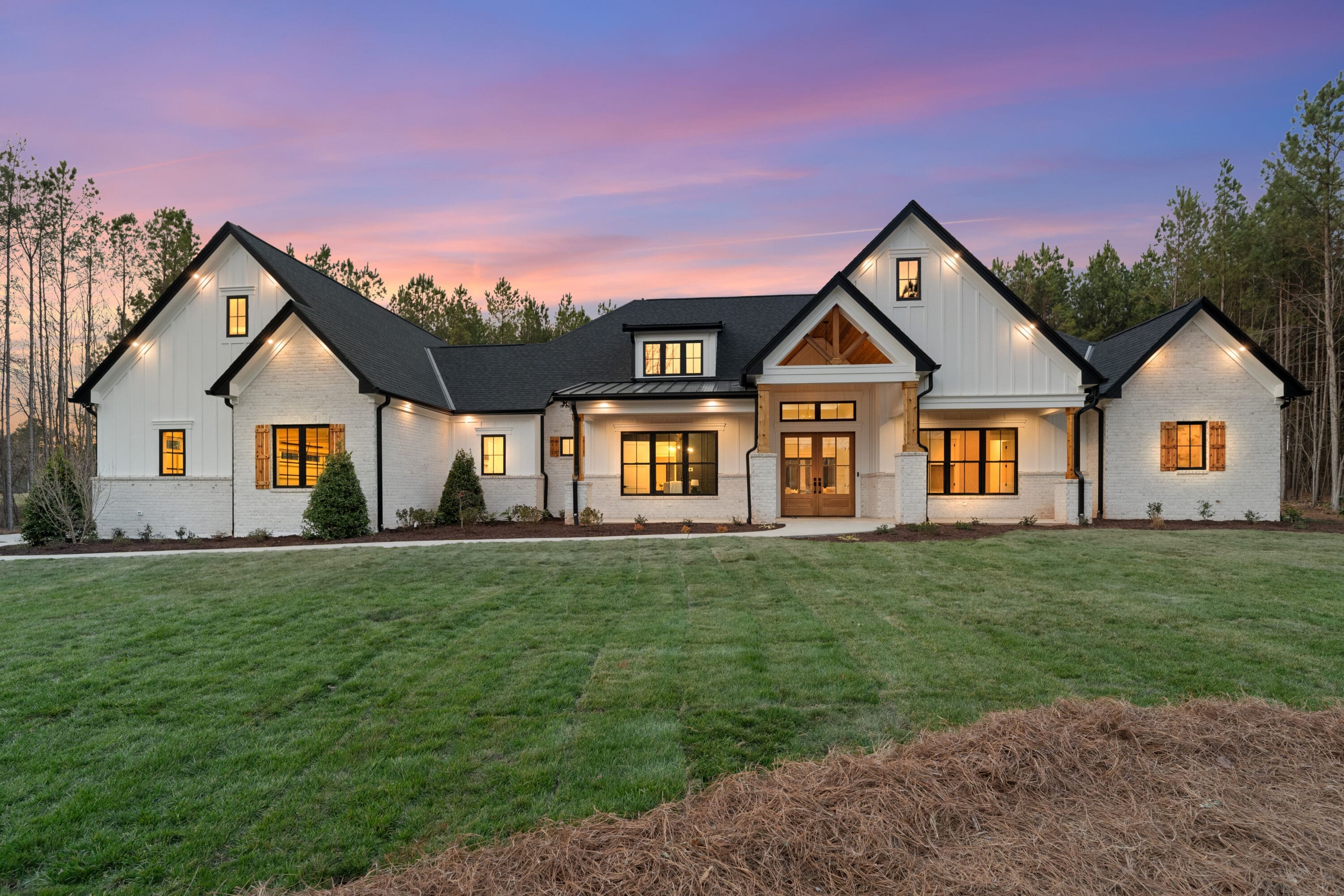 Beautiful modern farmhouse with a sunset sky backdrop.