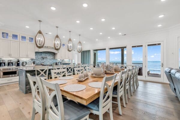Spacious dining area with wooden table and modern kitchen.