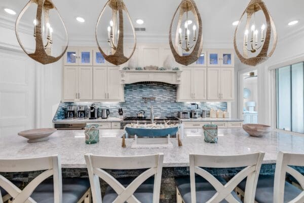 Modern kitchen with marble countertops and a stylish island under pendant lights.
